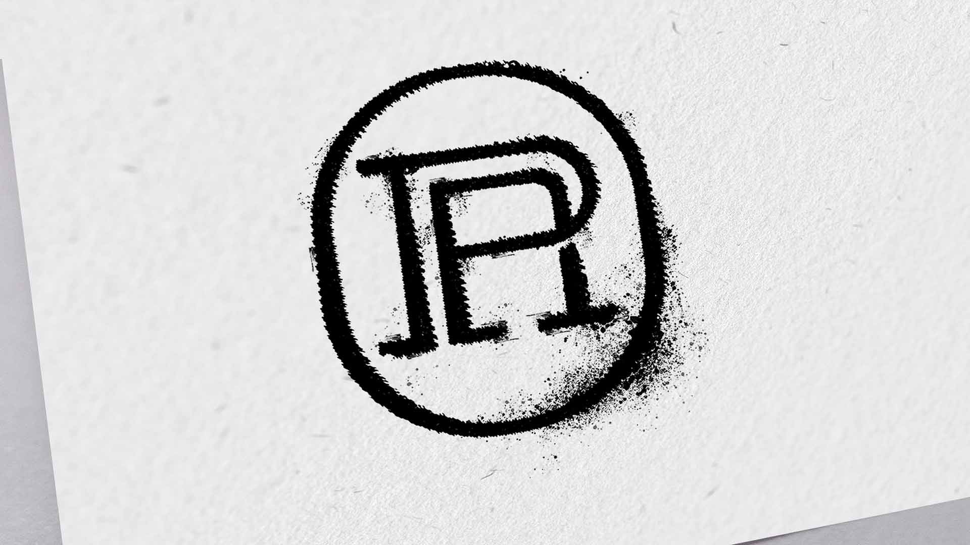 Macro detail of a distressed black ink stamp featuring the circular Acqua di Portofino monogram icon on textured white paper stock.
