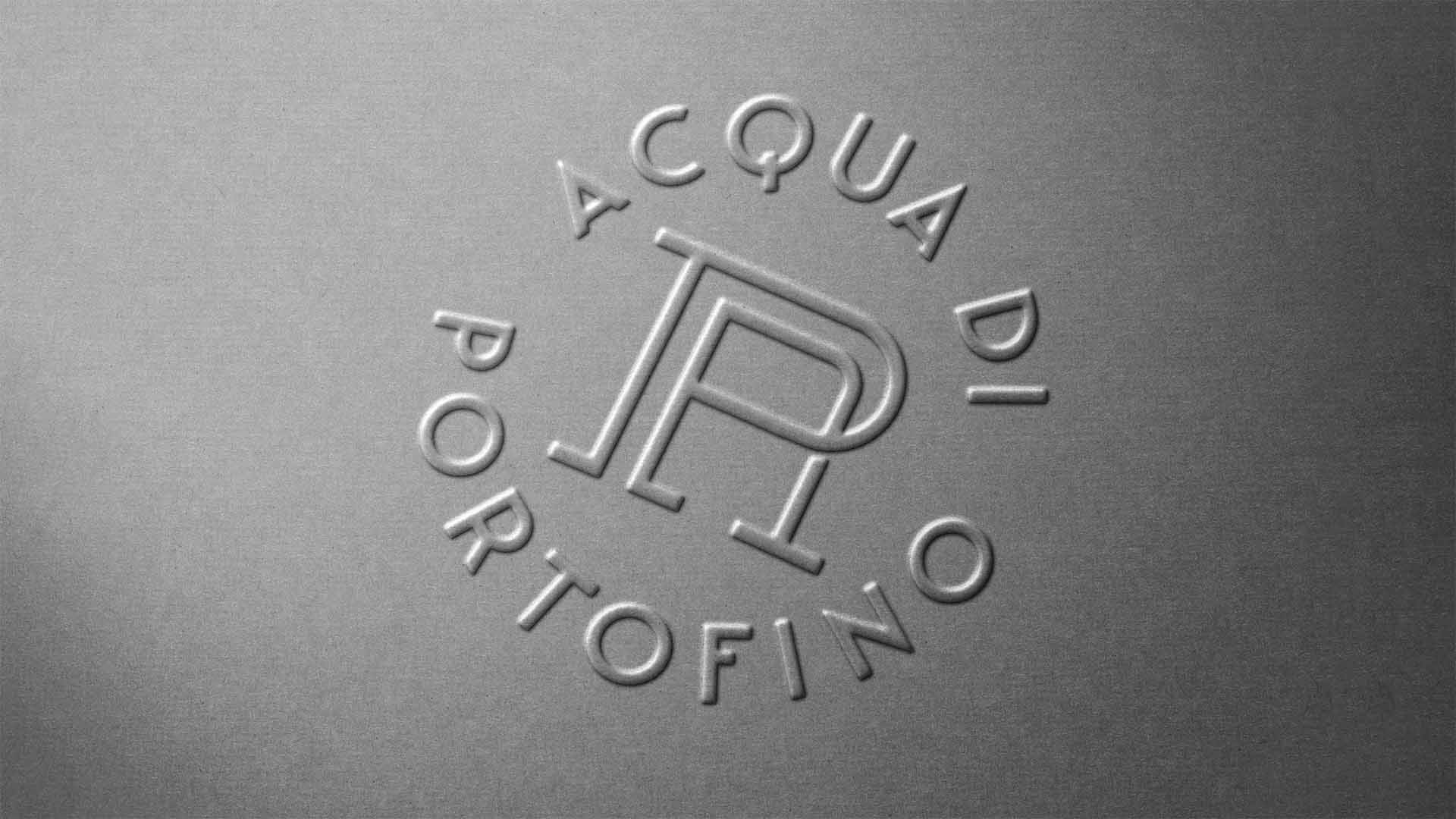 Macro detail of tactile embossed circular monogram and custom typography on textured paper stock.