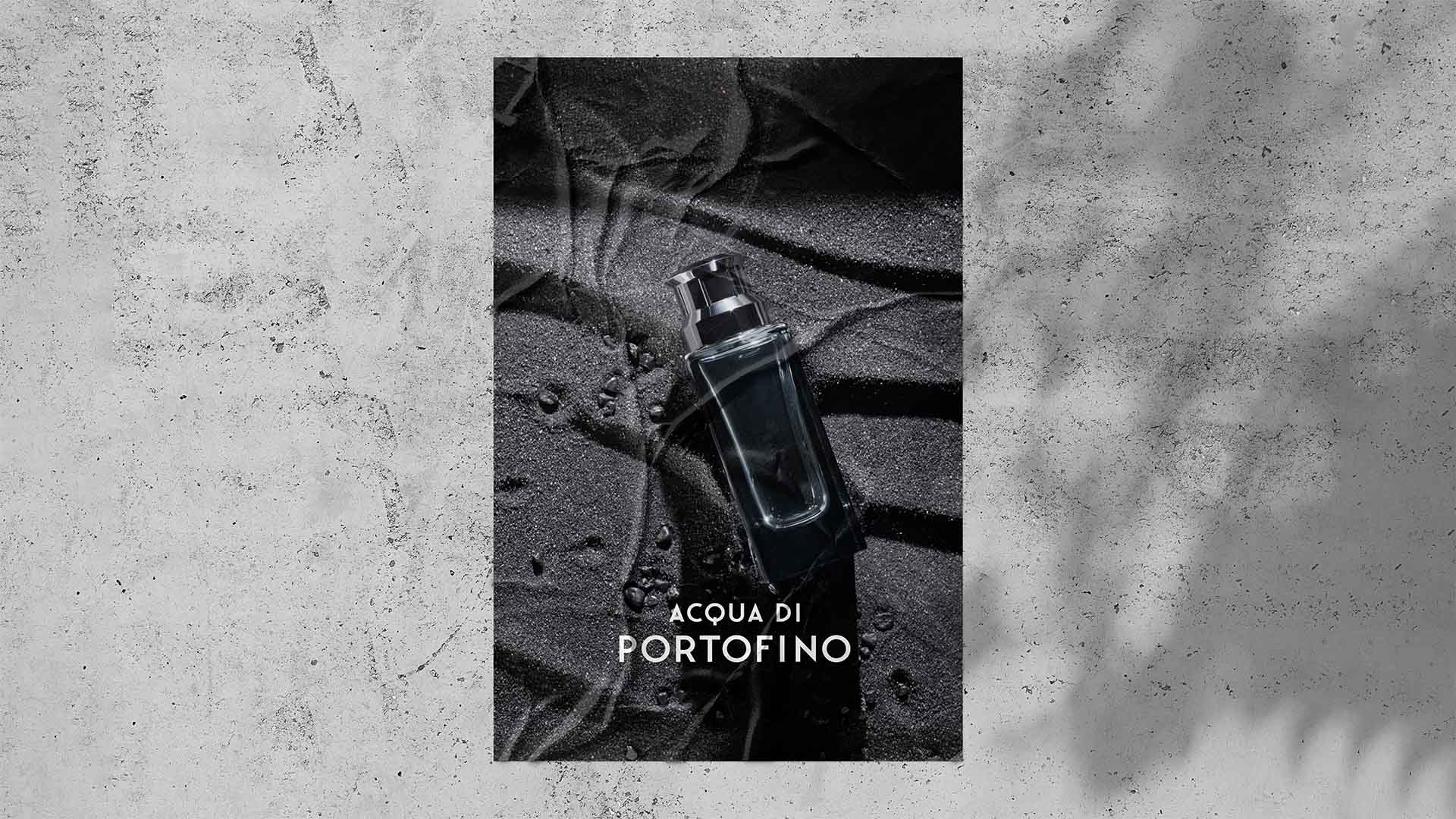 Wildposting campaign poster on a textured concrete wall featuring a dark perfume bottle on black sand.