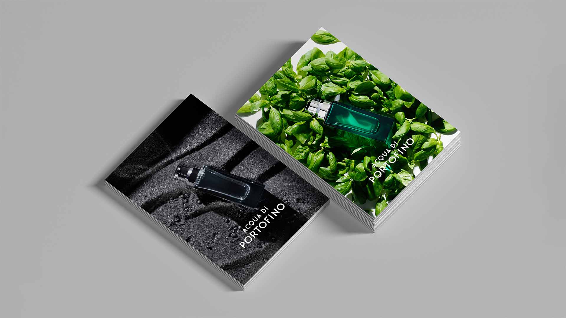Stack of printed promotional postcards featuring campaign imagery on basil leaves and black sand.