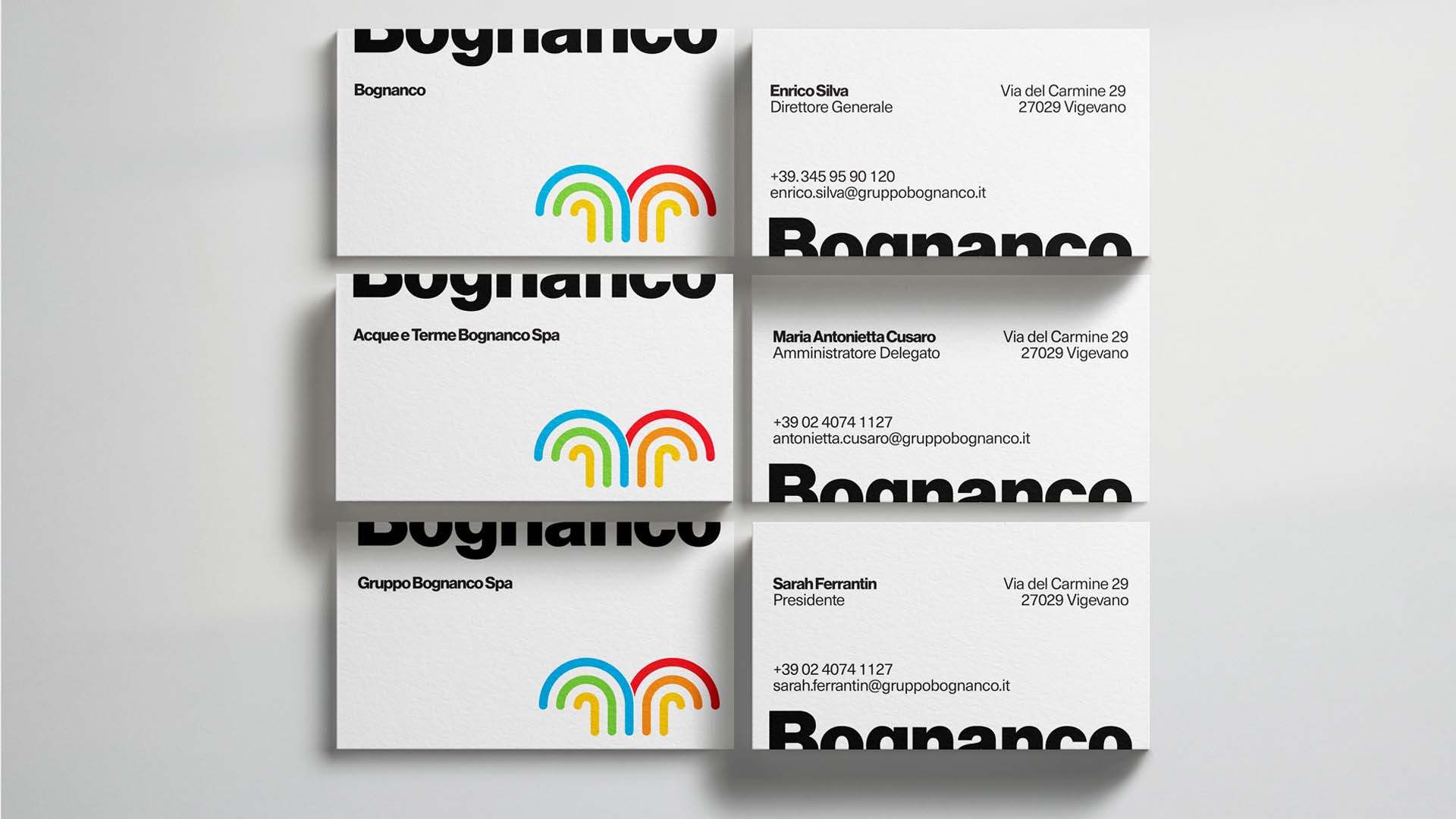 Collection of executive white business cards showing typography layouts and colorful fountain icon.