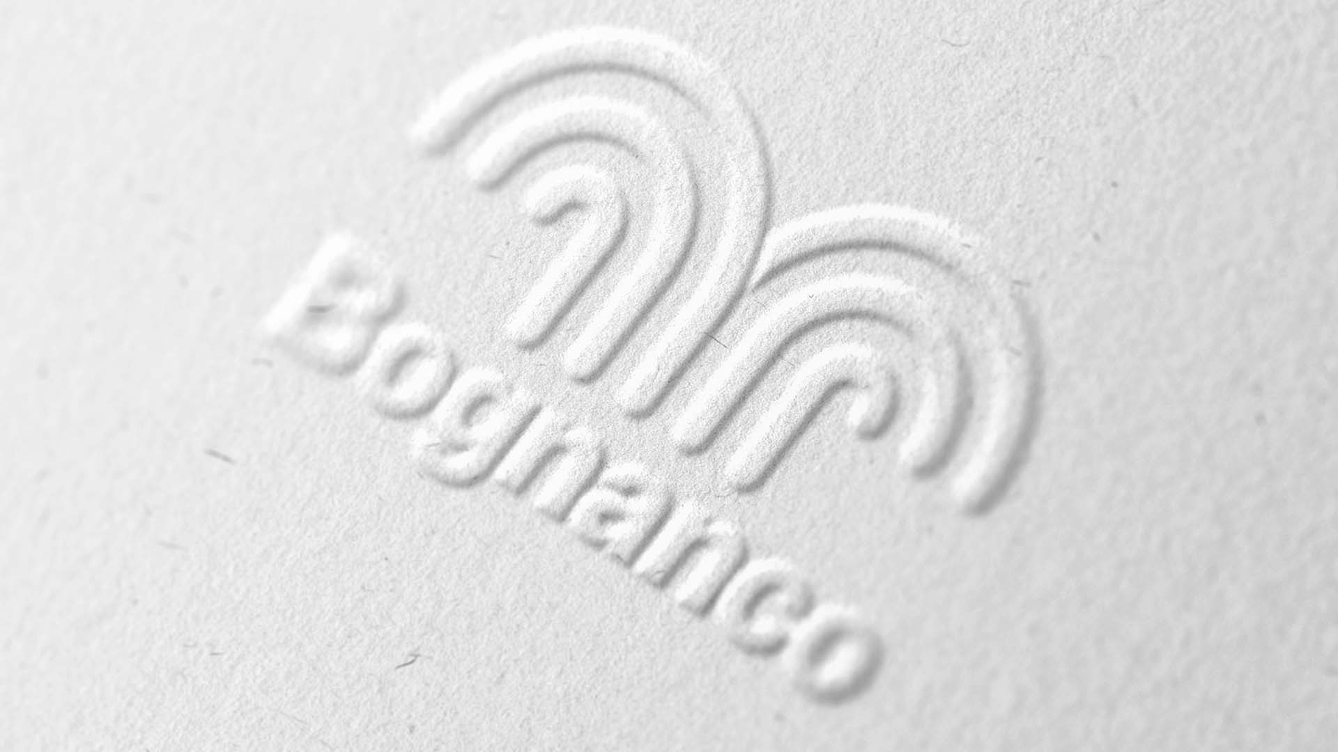 Macro photograph of tactile white textured paper with blind-embossed Bognanco fountain symbol and logotype.
